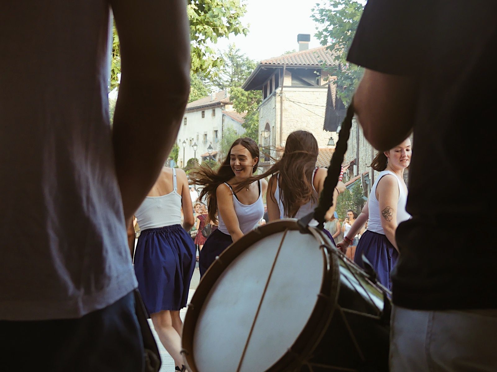 Basque dancers moving through a village street framed by drummers.
