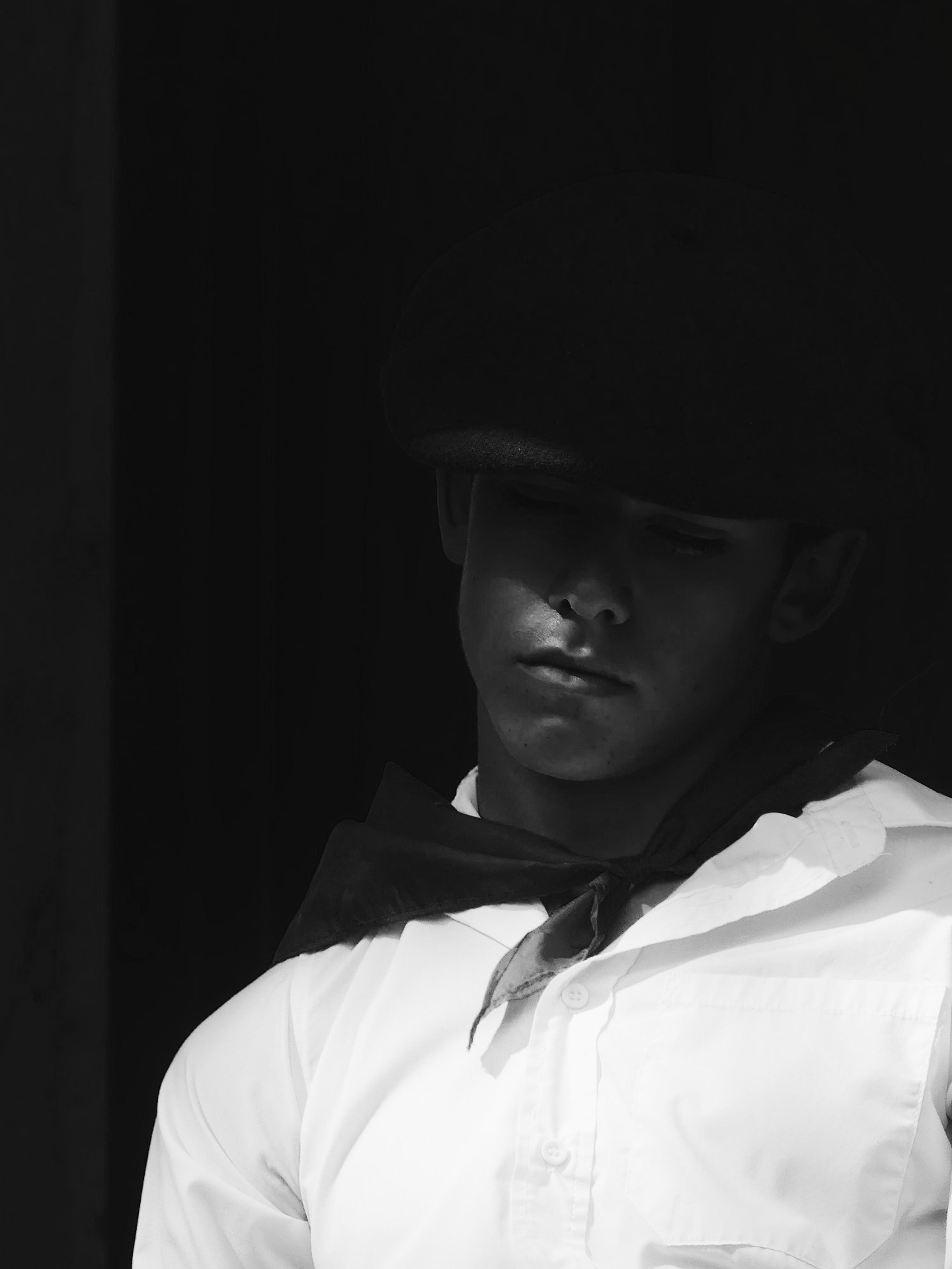 Black and white portrait of a young performer in a beret and scarf.