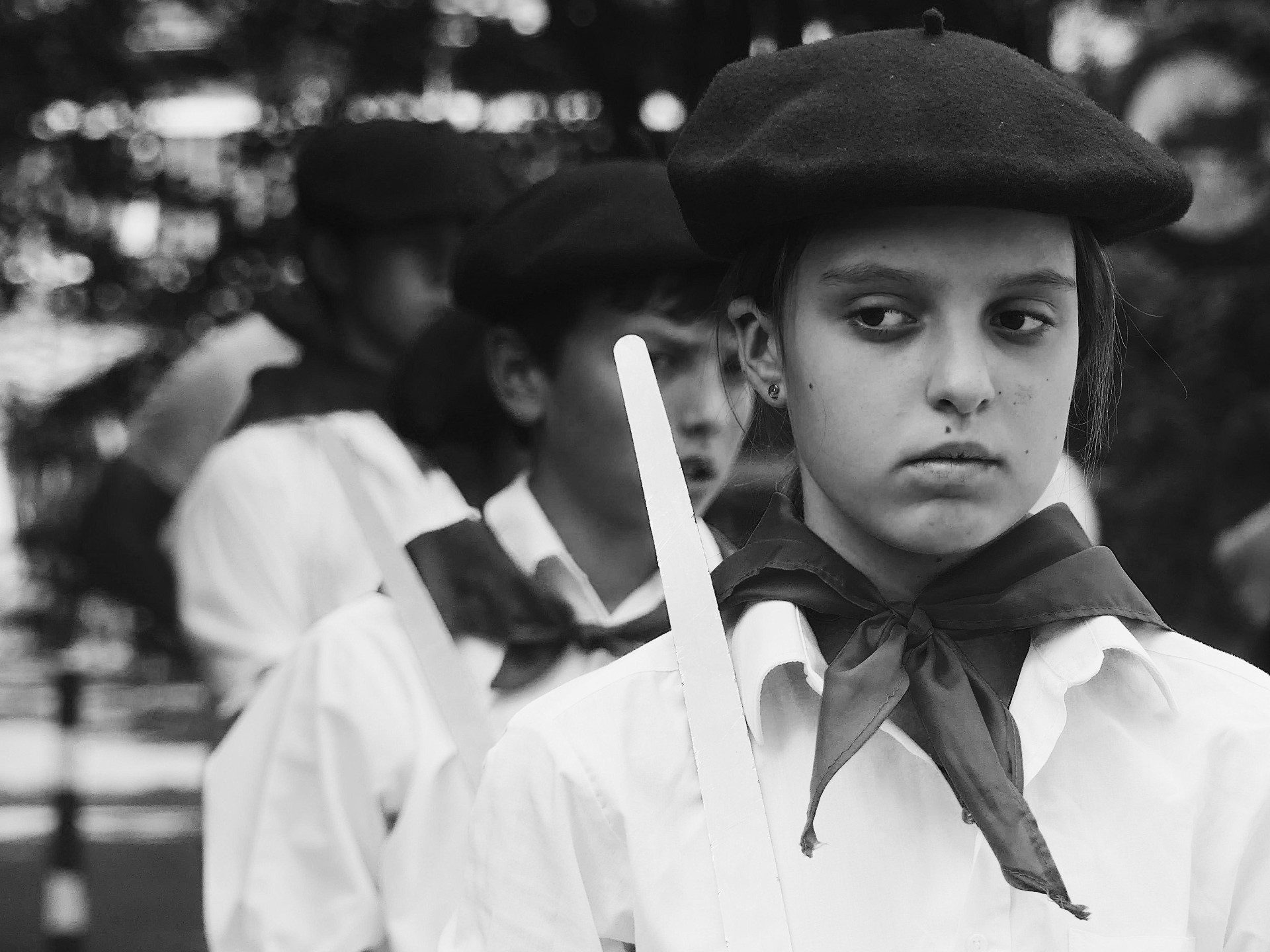 Black and white portrait of a young girl in traditional festival clothing and beret.