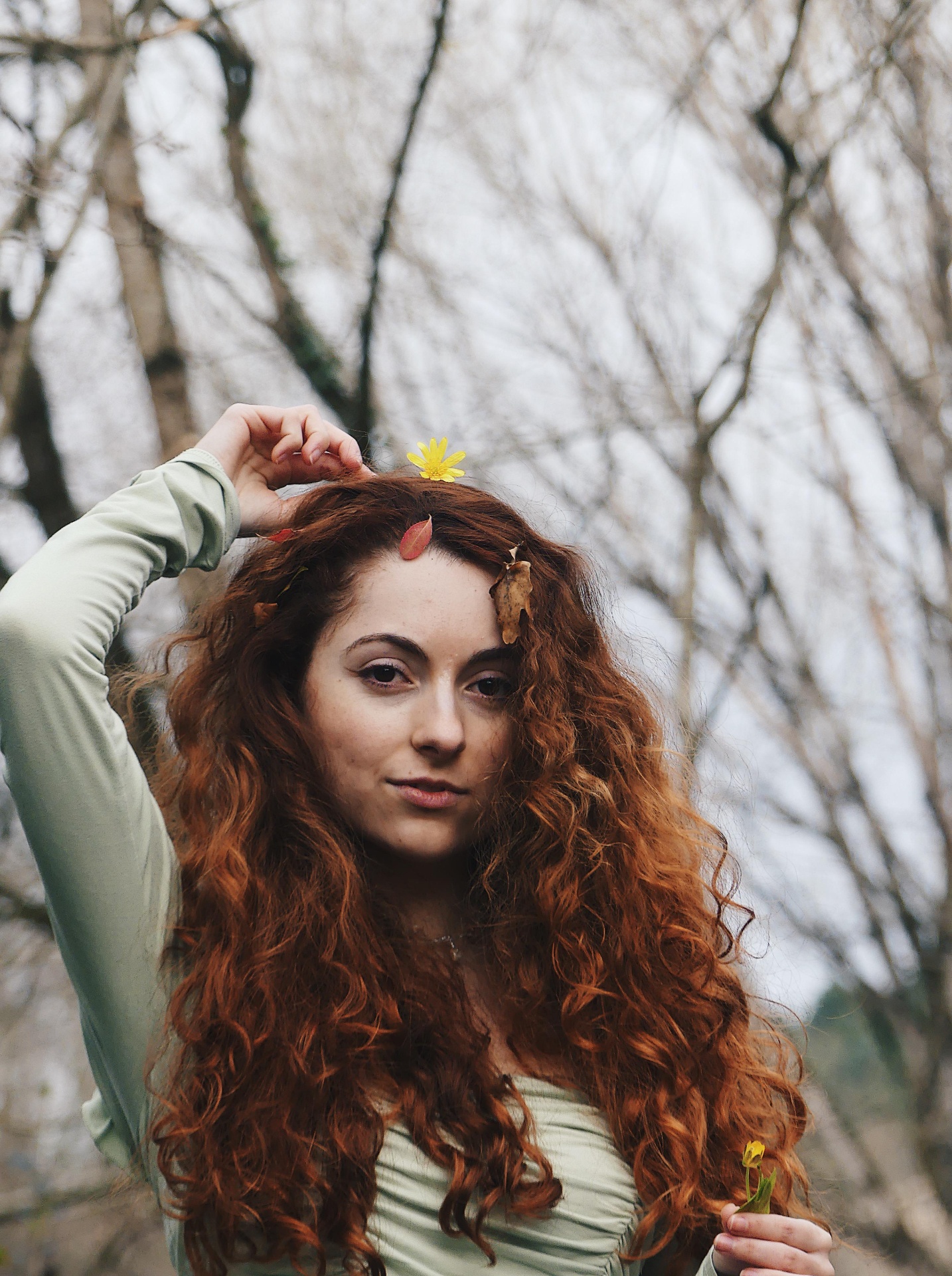 Portrait in winter forest with curly red hair.
